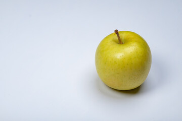 a whole flesh yellow-red orin apple  covered with small water droplet with shadow from backlight a in white background with clipping path