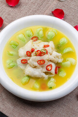 Longli fish in sour soup in a white round porcelain plate