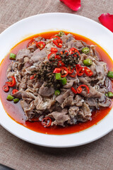 White round porcelain plate with boiled beef in hot pepper sauce