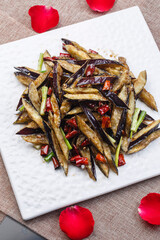 Spicy fried eggplant in a square white porcelain plate
