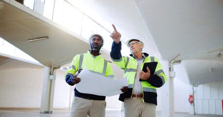 Construction, pointing and men with blueprint in building for collaboration, project ideas and...