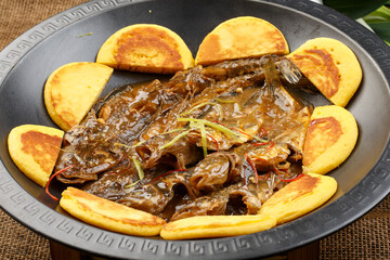 Black iron pot with seafood and fish pancakes