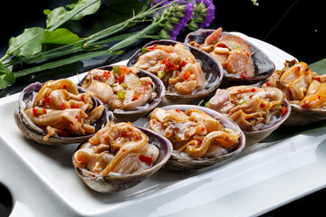 Seafood charcoal grilled purple stone clam swan eggs in a tripod-shaped porcelain plate