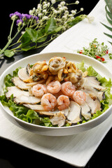 Three fresh seafood in sauce served on a white round porcelain plate