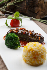 Rice with sea cucumber and meat sauce served in a rectangular white porcelain plate