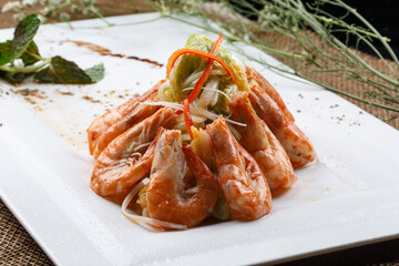 Square white porcelain plate with fried prawns and choy sum