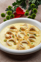 Steamed egg with seafood and clam meat on white porcelain plate