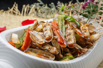 Spicy fried razor clams in a white porcelain plate