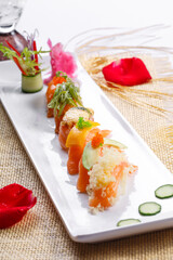 Assorted salmon nigiri sushi on a straw mat