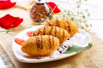 Deep fried golden chicken balls on a white porcelain plate