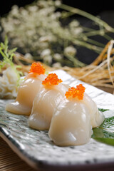 Teriyaki scallop and crab roe sushi on a sushi curtain