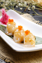Teriyaki scallop and crab roe sushi on a sushi curtain
