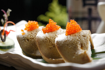 Crab roe and grilled foie gras sushi on a rectangular porcelain plate
