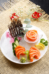 Salmon sashimi is placed on the grass mat