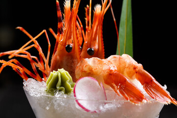 Two pieces of Arctic sweet shrimp sashimi placed in a tall glass filled with crushed ice