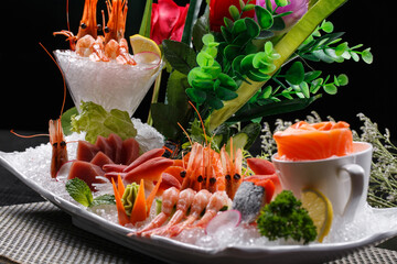 A luxurious and sumptuous sashimi platter is placed on the placemat