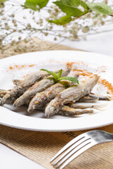 Japanese style grilled salt and pepper capelin placed on English wrapping paper