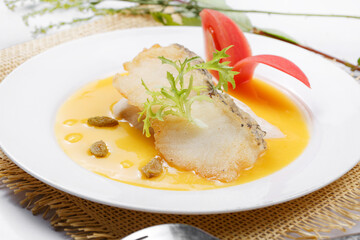 Codfish with French pumpkin sauce served on a straw mat