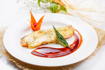 Norwegian salmon baked with cheese and red wine sauce served on a straw mat