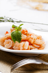 Sizzling shrimp and enoki mushrooms are placed on English wrapping paper