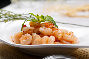 Sizzling shrimp and enoki mushrooms are placed on English wrapping paper