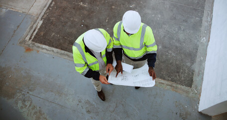 Construction site, above and men with blueprint in building for collaboration, project ideas and renovation. Engineering, architecture team and people with documents for floorplan, layout and design