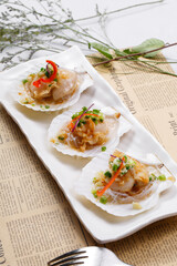 Steamed scallops with garlic vermicelli and XO sauce on English wrapping paper