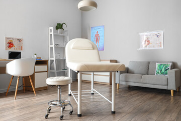 Interior of medical office with couch, sofa and doctor's workplace