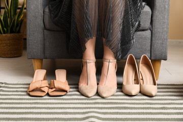 Young woman choosing shoes at home