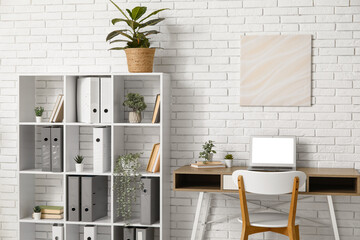 Interior of office with shelf unit, folders and workplace