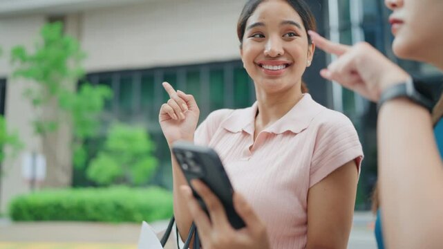 Women using smartphone app for navigation, looking for direction in urban setting