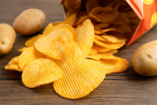 Potato chips, delicious BBQ seasoning spicy for crips, thin slice deep fried snack fast food in open bag.