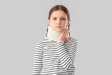 Cute girl in cervical collar on light background