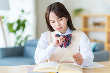 自宅で勉強中に悩む女子高生