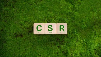 Corporate and community social responsibility concept CSR icon on wooden block, green moss nature...
