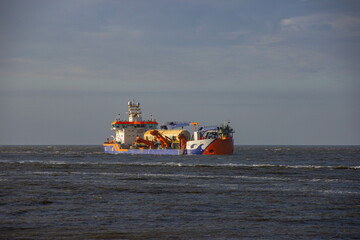 Cargo ship sailing through the Baltic Sea near the German coast on a sunny day. Maritime transport,...