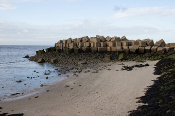 Concrete sea defense blocks on a rocky Baltic Sea shoreline, designed to prevent coastal erosion...