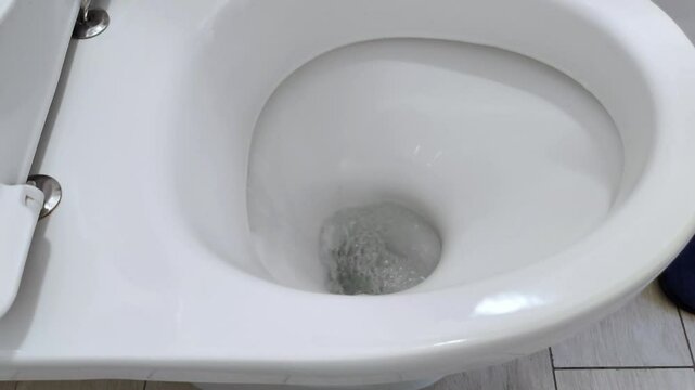 A low hiss, a bubbling stir-water in the toilet shifts and vanishes, pulled away by invisible heat and quiet noise