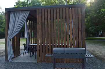 Outdoor dining and grilling area with wooden shelter