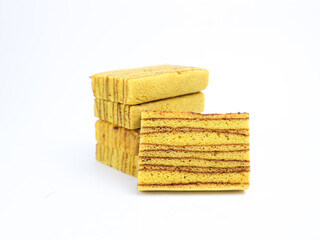 Indonesian layered cake slices (kue lapis legit) stacked on white background. Traditional sweet...