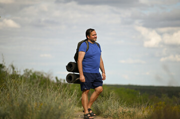 a man with a backpack goes on a journey in the summer