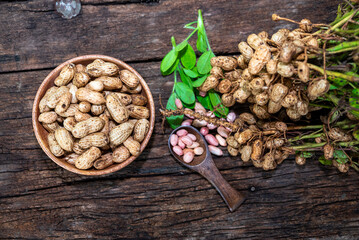 Peanuts in a peel in a wooden bowl. peeled peanut on peanut group on wooden bowl.
