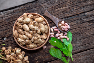 Peanuts in a peel in a wooden bowl. peeled peanut on peanut group on wooden bowl.