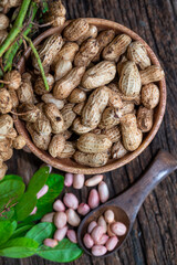 Peanuts in a peel in a wooden bowl. peeled peanut on peanut group on wooden bowl.