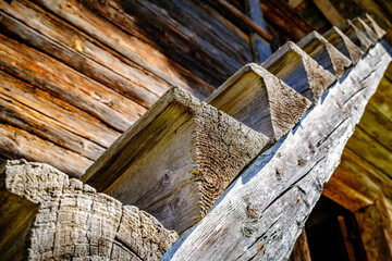 Rustic wooden staircase leading to a weathered cabin in a serene natural setting during bright...