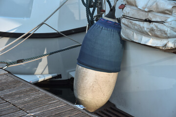 Parafender blu della barca appeso al pontile in legno