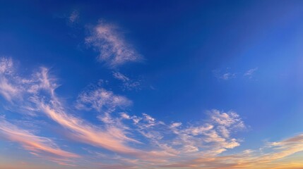 Fototapeta premium Expansive Azure Sky with Cirrus Cloud Streaks and Golden Sunset Glow Near Horizon