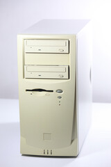 A detailed front view of an old-fashioned beige computer tower, featuring multiple disk drives and...