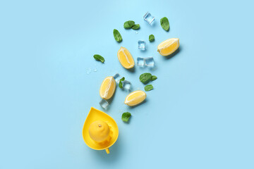 Composition with fresh sliced lemons, mint and ice on blue background