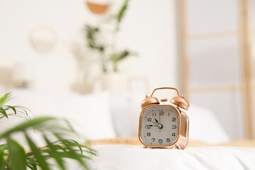 Alarm clock on bed in bedroom, closeup